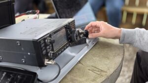 Hand eines Funkamateurs bedient den VFO eines Funkgeräts